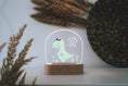 Load image into Gallery viewer, Nachtlicht aus Acryl "bunter Dino", Holzfuß graviert, Geschenk zur Geburt , Personalisierte Erinnerungsstücke, Geschenke für Kinder, LED