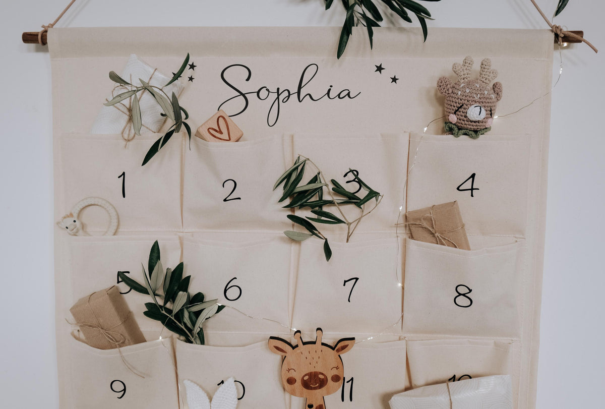 Oberer Teil des Stoffkalenders mit Namen in Schreibschrift über den Taschen 1 bis 8, gefüllt mit kleinen Geschenken