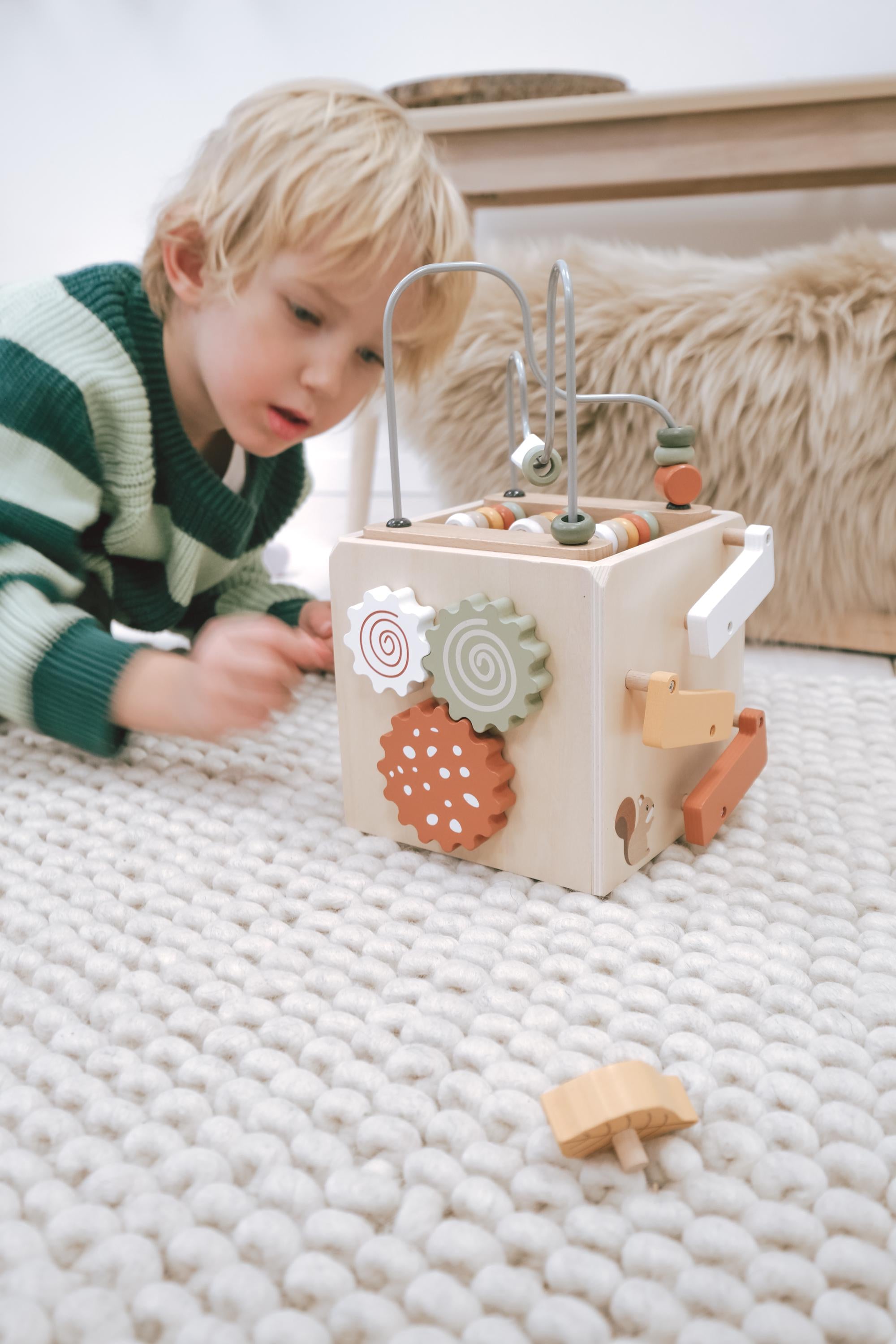 Holzspielzeug für Kinder und Babys ab 12 Monaten mit Steckspiel und EN-71-Zertifikat, präsentiert in einem modernen Kinderzimmer.