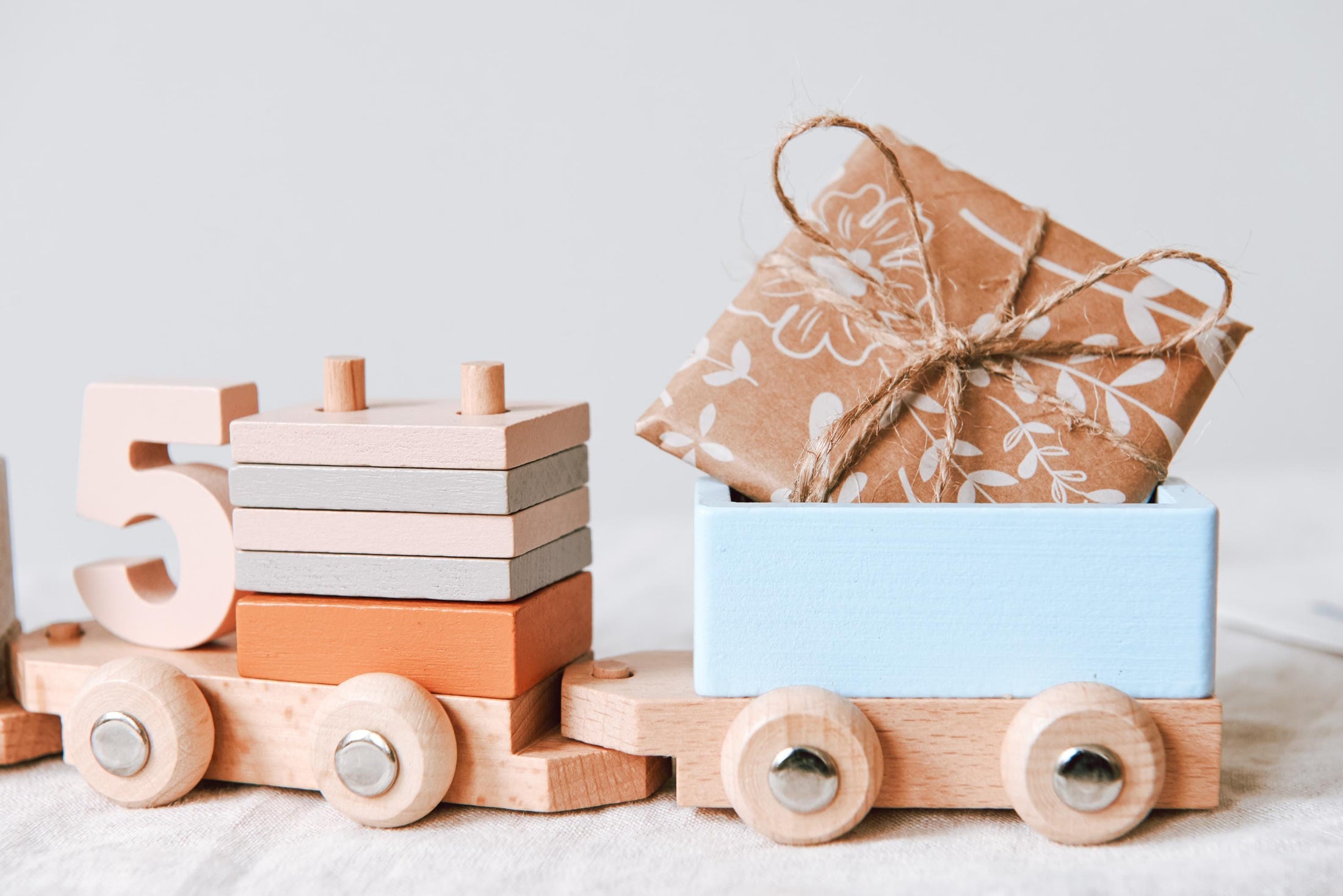 Holzspielzeug-Eisenbahn mit Bausteinen beladen und Geschenken, schadstofffrei, gefertigt aus nachhaltigem Holz, dekorativ und lehrreich.