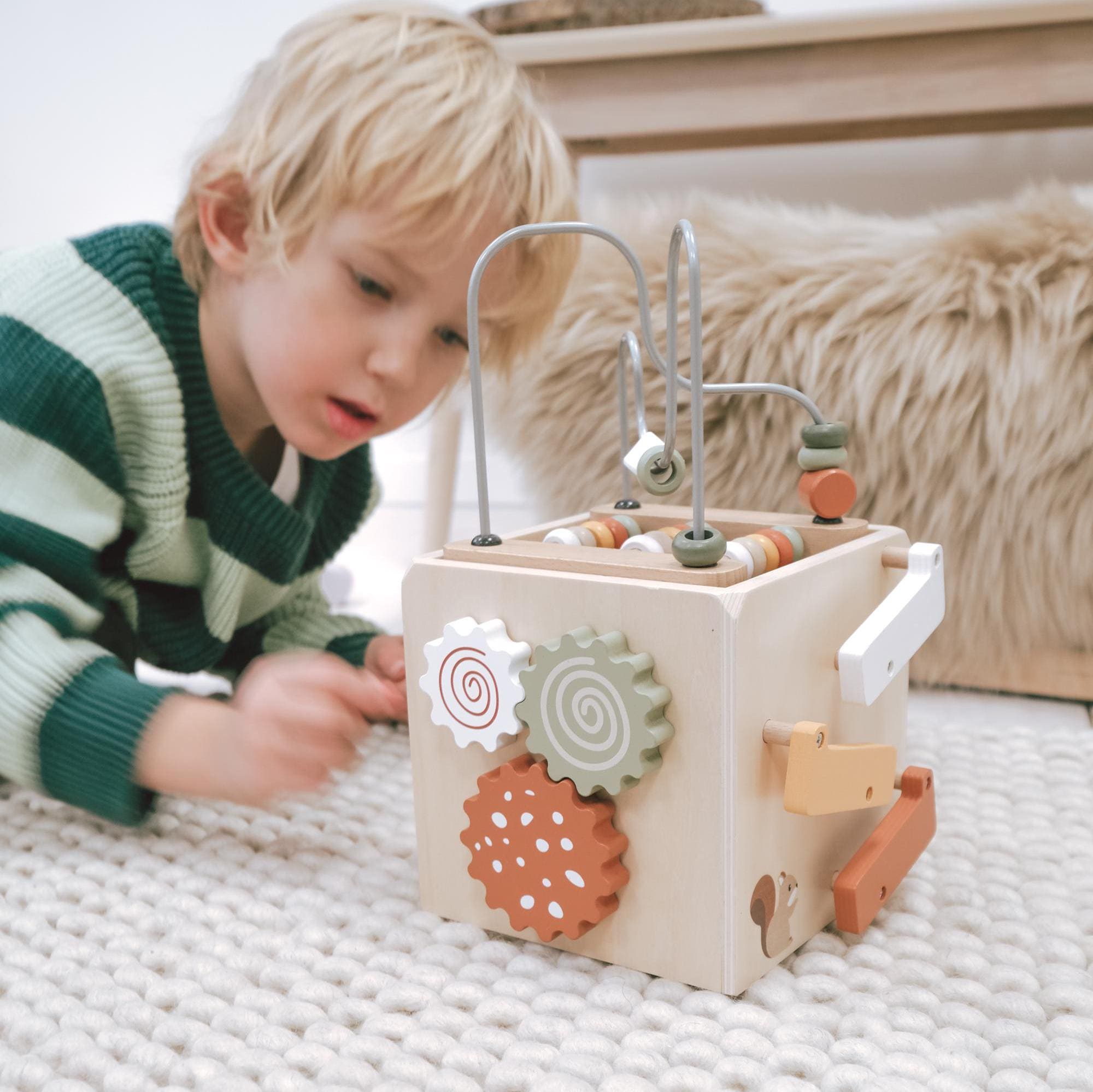 Holzspielzeug für Kinder und Babys ab 12 Monaten mit Steckspiel und EN-71-Zertifikat, präsentiert in einem modernen Kinderzimmer.