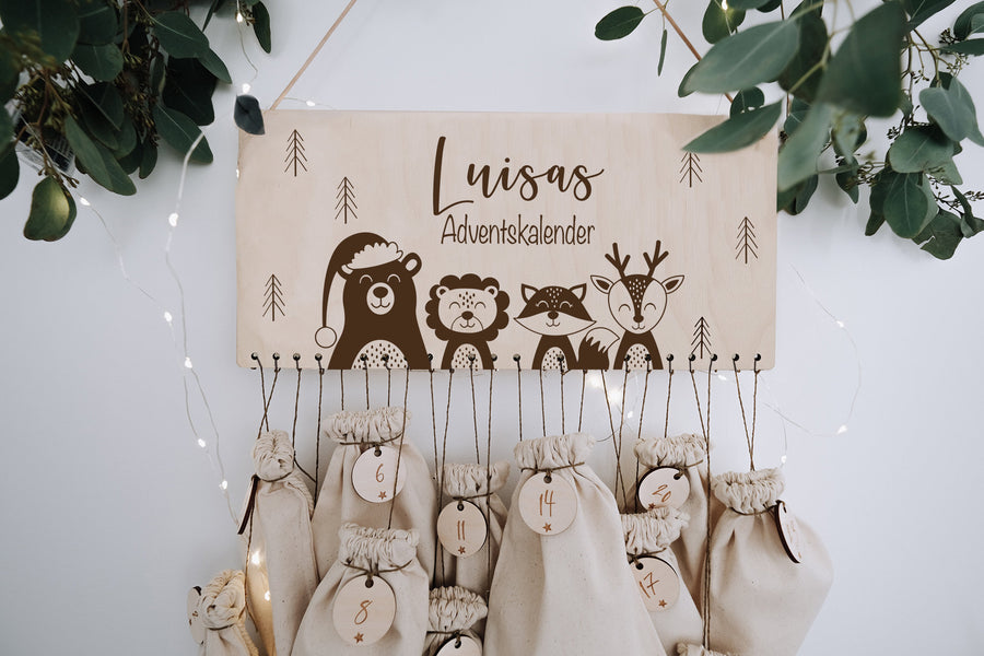 Adventskalender aus Holz mit gravierten Tieren Bär, Löwe, Fuchs und Hirsch, mit Namen, darunter Säckchen mit Zahlen