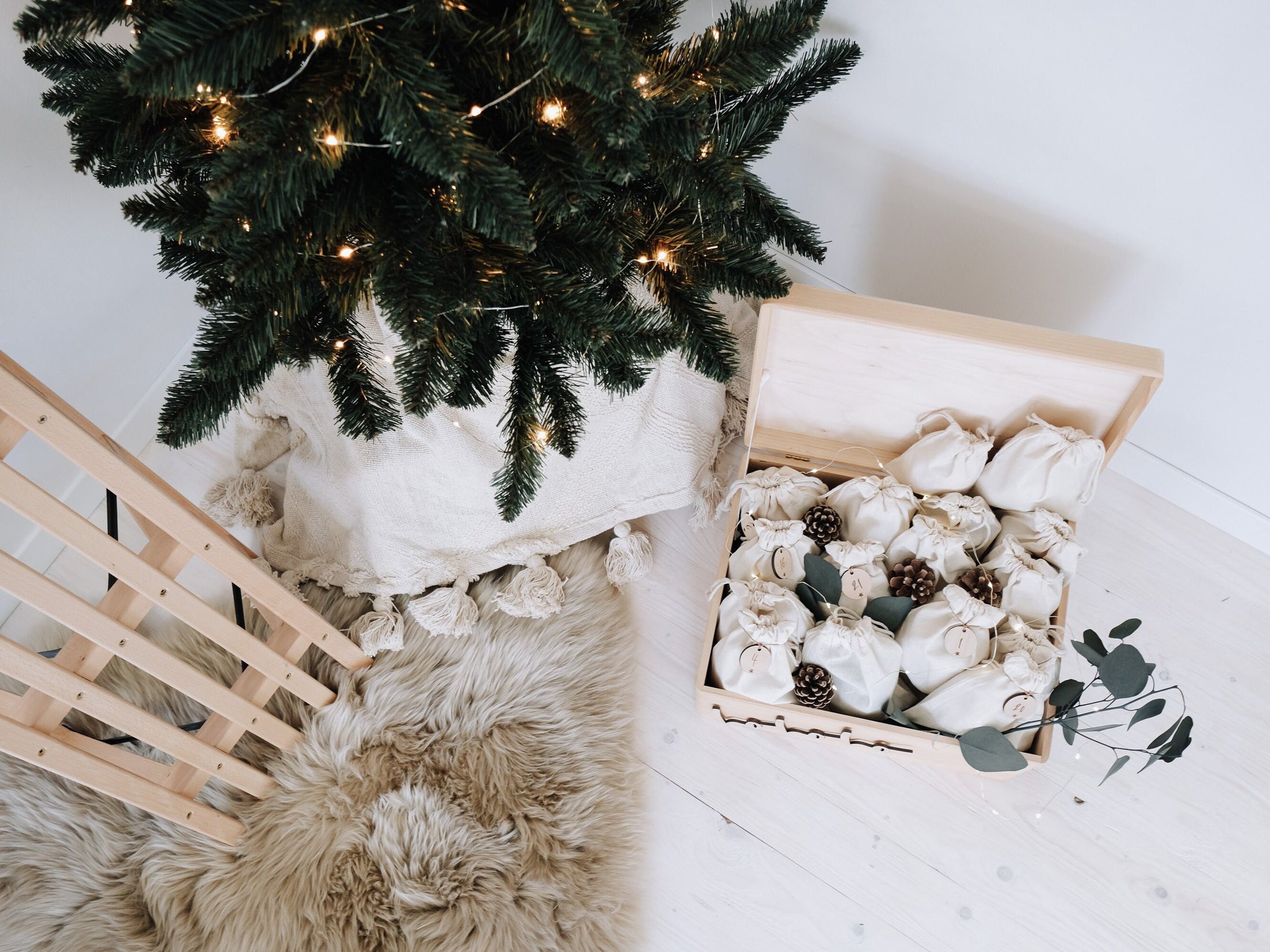 bunte Holzkiste für Adventskalender mit baumwollsäckchen in natur und unterschiedlichen Größen