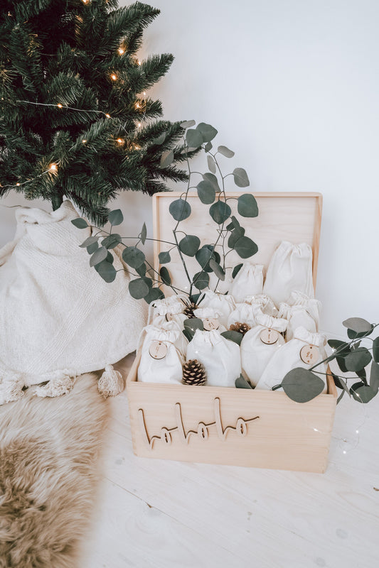 Adventskalender in der Kiste mit Baumwollsäckchen und Holzzahlen