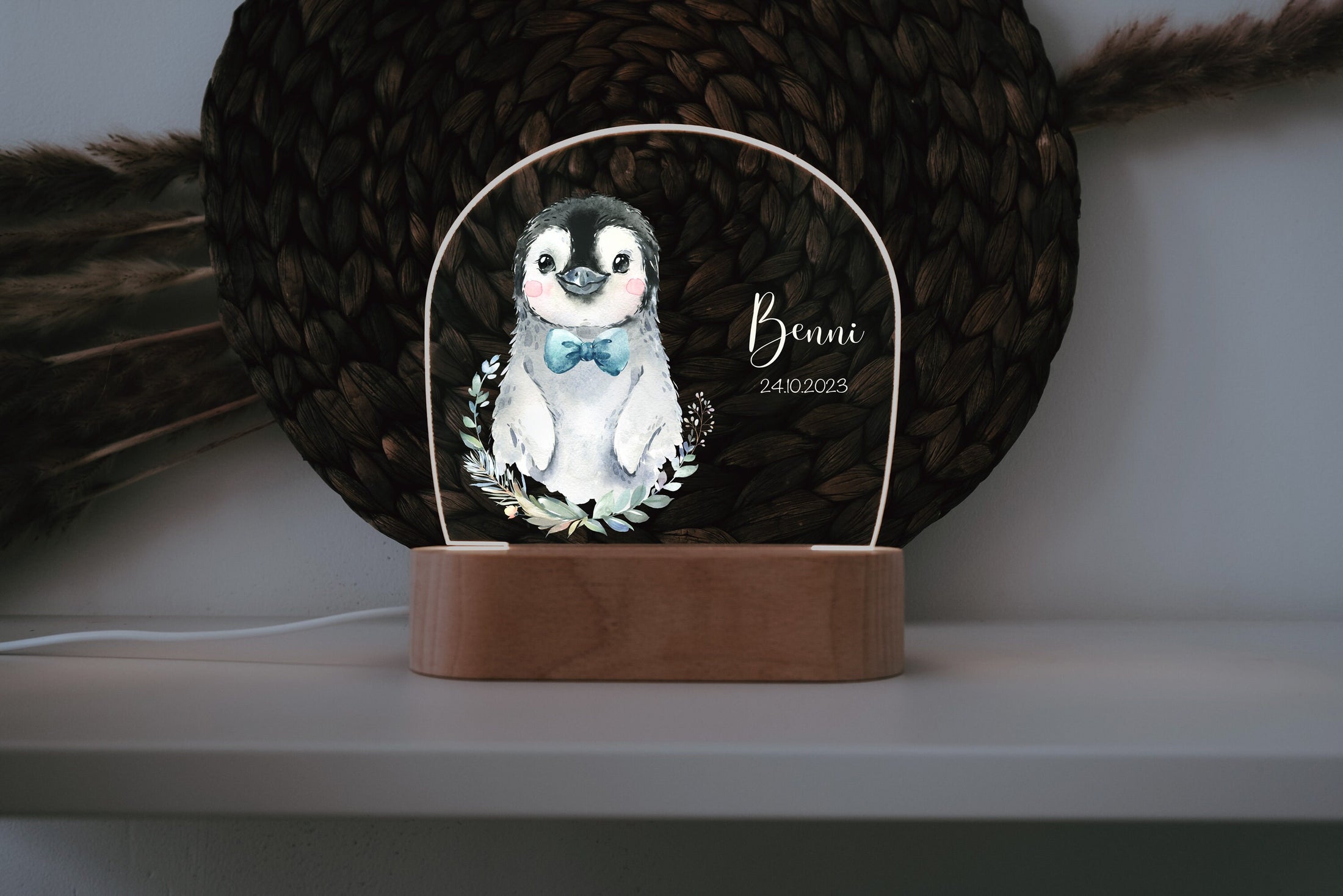 Acrylglas Nachtlicht in dunklem hintergund mit süßem Pinguin und personalisierbarer Widmung auf dem Glas und Sockel aus holz